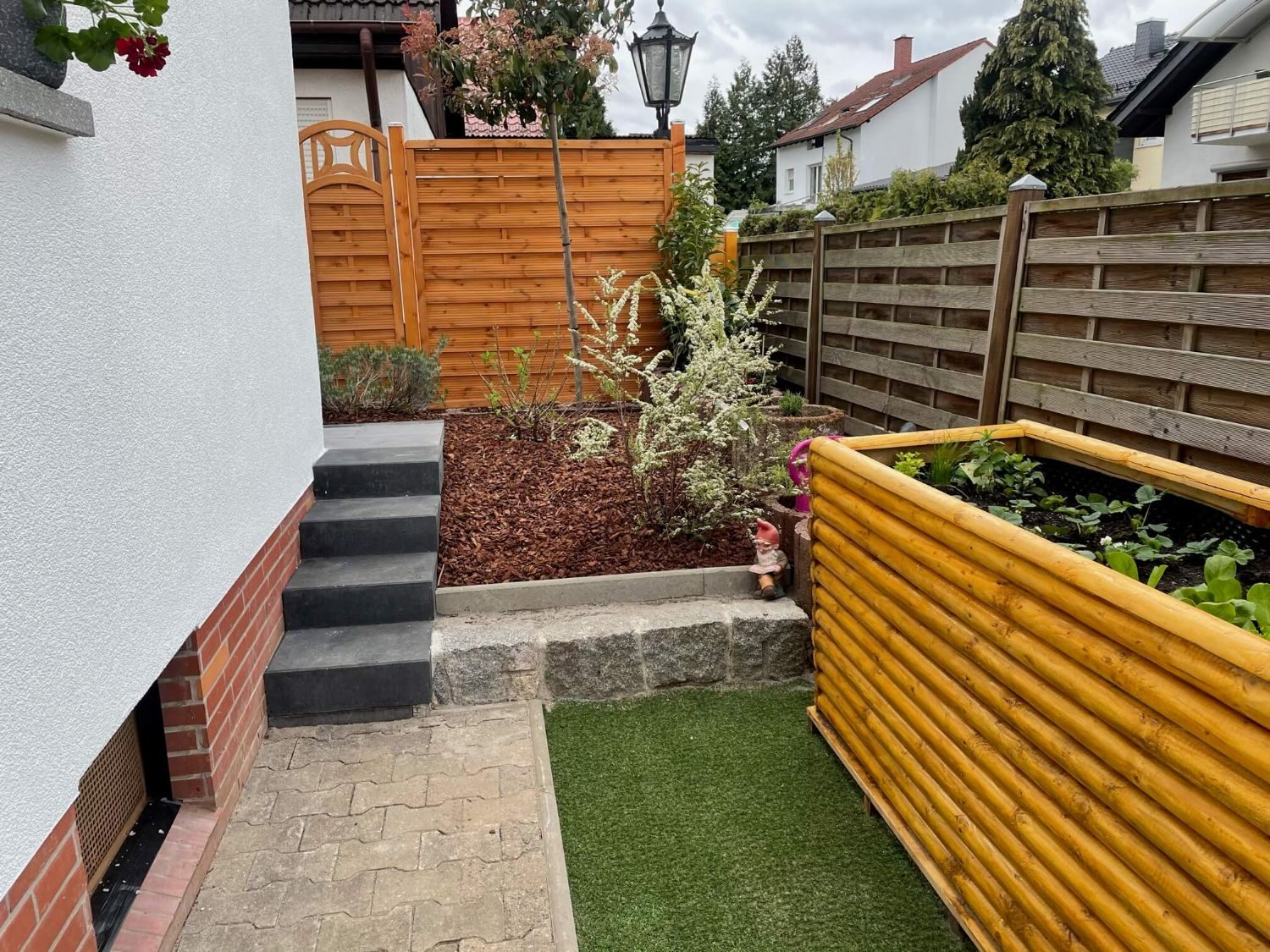 Gärtner in Darmstadt: neu gestalteter Vorgarten mit Treppe, Rindenmulch-Beet und Hochbeet